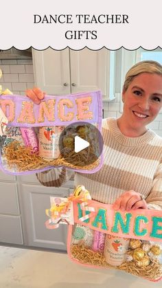 a woman holding up a dance gift in front of a kitchen counter with the words dance on it