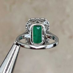 A bold ring featuring a 5.38 carat vivid green Zambian emerald. The center stone is surrounded by a halo of baguette-cut diamonds weighing 0.87 carats total. Adorning the shoulders are additional micro-pave set round brilliant cut diamonds weighing approximately 0.14 total. This ring is handcrafted in platinum. This ring is certified.
The measurements of this ring including the halo are approximately 16.78mm x 12.86mm. The approximate measurements of the emerald are 12.44mm x 8.12mm.
The current Luxury Octagon Emerald Ring In Platinum, Luxury Vintage Emerald Ring In Platinum, Heirloom Platinum Emerald Ring, Gia Certified, Green Emerald-cut Platinum Halo Ring, Luxury Green Emerald-cut Halo Ring, 3 Carat Ring, Vintage Diamond Earrings, 2 Carat Ring, Kunzite Ring