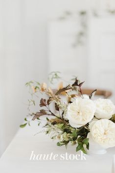 a white vase filled with flowers on top of a table