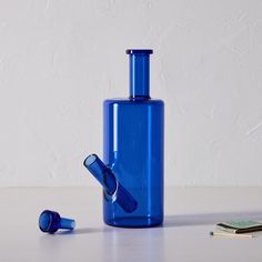 a blue glass bottle sitting on top of a table next to a pair of scissors