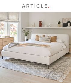 a white bed sitting on top of a wooden floor