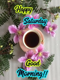 a cup of coffee sitting on top of a saucer next to pink flowers and green leaves