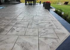 an outdoor patio with stone pavers and chairs