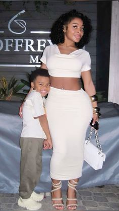 a woman standing next to a little boy in front of a sign that says coffee m