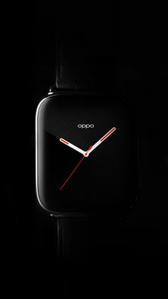 a black square clock with red hands in the dark