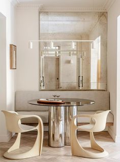 an elegant dining room with modern furniture and mirrors