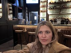 a woman sitting at a table in front of a bar