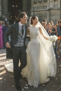 a bride and groom walking down the aisle after their wedding ceremony in front of an audience