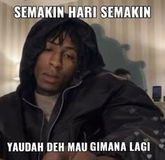 a man in a black hoodie sitting down with his hand on his hip and the caption says semakin hari semakin