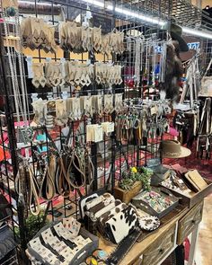 a table topped with lots of purses and other items next to a metal rack