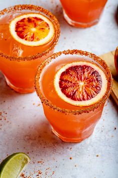 two glasses filled with blood orange margaritas and garnish