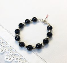 "When you need to grab that perfect understated bracelet that goes with everything - this is the one! Beautiful 10mm black onyx beads paired with faceted antiqued (oxidized) silver plate rondelle beads make this the go-to piece.    Dress it up, dress it down, take it to work, take it on a date, take it on a night out with the girls, and of course... wear it with your favorite jeans and tee-shirt.  The bracelet closes with a silver lobster clasp and adjusts from 7.25\" to 8.0\"   Oh, and don't forget to stack this with all your other favorites. Enjoy!" Black Nickel-free Bracelets With Round Beads, Multi Gemstone Bracelet, Black Onyx Bracelet, Onyx Bracelet, Onyx Bead, Oxidized Silver, Adjustable Bracelet, Chicago Il, Gemstone Bracelet