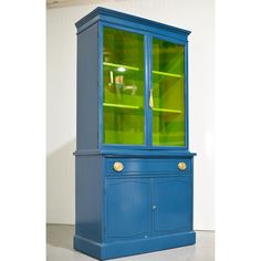 a blue china cabinet with green glass doors