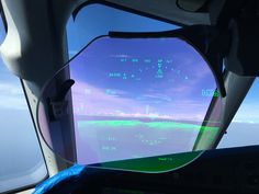 the view from inside an airplane looking out at water and land with blue skies in the background