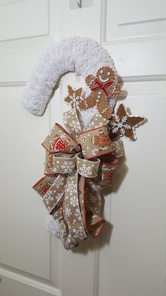 a christmas wreath hanging on a door with snowflakes and reindeers around it