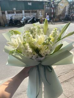 someone holding a bouquet of flowers on the street