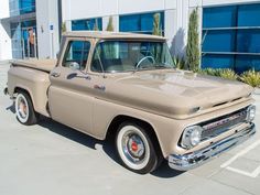 an old pickup truck parked in front of a building