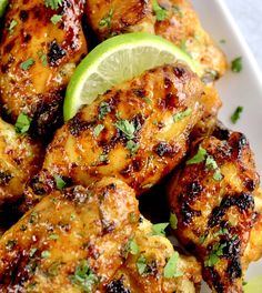 grilled chicken wings with lime wedges and parsley on the side, ready to be eaten