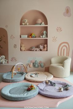 Cozy and colorful nursery featuring soft play mats, a plush chair, and decorative shelves with toys and stuffed animals, all set against a pastel pink wall with playful designs. Play Space In Living Room