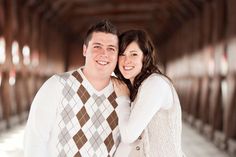 a man and woman are standing together in an old building with wooden floors, smiling at the camera