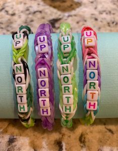 four bracelets that say support, hope, north and south on them sitting next to each other