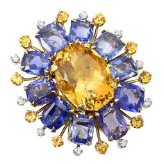 A bold floral ring centered with a large mixed cut oval shape citrine clustered with ten natural, no heat square cushion shape blue sapphires spaced with ten stems hosting yellow sapphires and accented with ten round brilliant-cut diamonds; size 6 1/4 US Vintage Cocktail Ring, Citrine Jewelry, Yellow Gold Diamond Ring, Fine Diamond Jewelry, Floral Ring, Diamond Cocktail Rings, Citrine Ring, Vintage Cocktail, Buying Diamonds