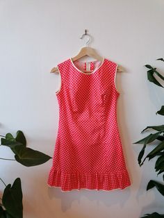 Celebrate the empowering spirit of the '60s with our Coral Polka Dot Mini Dress, a nod to mod fashion and female strength. This vibrant dress boasts a cheeky frilled hem, adding a touch of playfulness to your ensemble. Adorned with white spots, the coral backdrop creates a striking contrast, while white trims on the neckline, arms, and hem enhance the dress's retro charm.  Measurements: Chest: 45cm (pit to pit) Length: 80cm (neckline to hem) Waist: 71cm (28 inches) Elevate your wardrobe with thi Female Strength, 60s Mini Dress, Polka Dot Mini Dress, Mod Mini Dress, Vibrant Dress, Mod Style, Mod Fashion, Iconic Style, White Trim