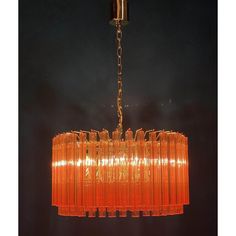 an orange chandelier hanging from the ceiling in a dark room with black walls