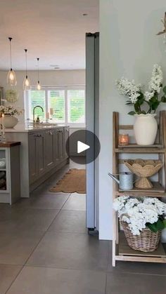 an open kitchen and living room with white flowers in vases