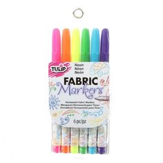 four different colored markers in a display case with the words fabric markers on it's side