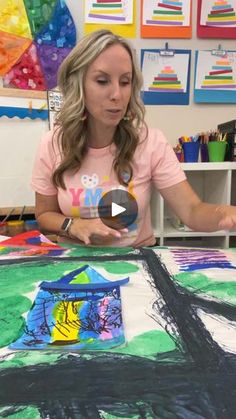 a woman sitting at a table with a painting on it