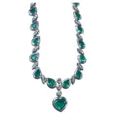 This remarkable necklace showcases an impressive 18-carat green emerald, beautifully complemented by 15 carats of additional natural green emeralds, all meticulously set in radiant 18K white gold. The centerpiece of this exquisite necklace is the breathtaking 18-carat emerald, which captivates with its rich, vibrant hue and exceptional clarity. Surrounding this magnificent gemstone, a series of expertly cut natural emeralds add to the necklace's allure, enhancing its overall brilliance and elega Dazzling Jeweled Emerald Necklace For Formal Events, Luxury Emerald Necklace With Jewels For Formal Occasions, Luxury Emerald Necklace With Jewels For Formal Events, Exquisite Jeweled Emerald Necklace For Anniversary, Luxury Emerald Necklace For Formal Events, Luxury Green Diamond Gemstone Necklace, Luxury Green Diamond Necklace With Gemstone, Luxury Green Gemstone Diamond Necklace, Luxury Green Diamond Necklace For Anniversary