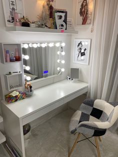 a white desk topped with a mirror and a chair next to an illuminated vanity table