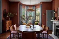 a dining room table with chairs and a fire place in the corner next to it