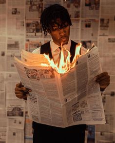 a man reading a newspaper with flames coming out of his face and hands behind him