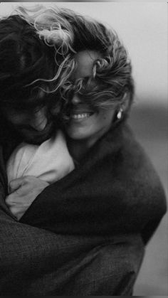 black and white photograph of two people hugging each other with their arms around one another