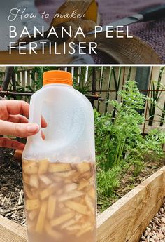 a bottle filled with banana peels sitting on top of a wooden box next to a garden