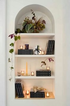 the shelves are filled with books and candles