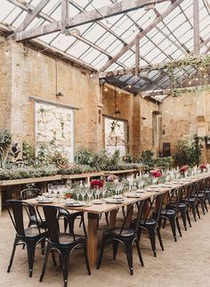 a long table is set up in the middle of an old building with lots of greenery