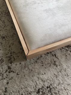 a close up of a bed frame on the floor with carpet in front of it