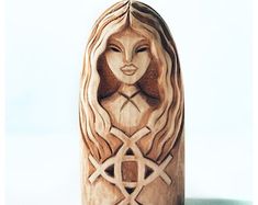 a wooden carving of a woman's face with long hair