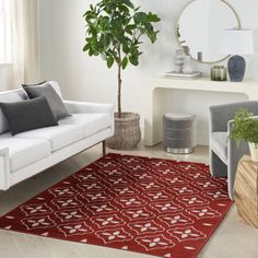 a living room filled with furniture and a potted plant on top of a rug