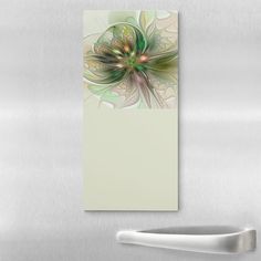 a white refrigerator freezer sitting next to a metal wall with a green flower on it