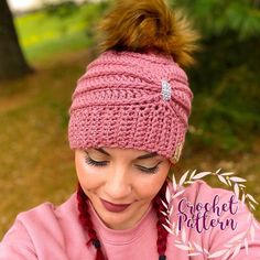 a woman wearing a pink hat with a brown pom - pom