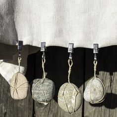 four stones hanging from hooks on a wooden fence