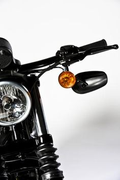 the front end of a black motorcycle on a white background