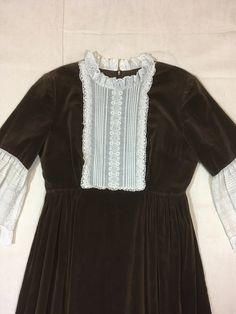 "1970s zip back dress Couriers California brown velvet lace trim empire waist bell sleeve ruffle trim neck/hem/sleeve TALON zip up back shirt is lined (not sleeves) good vintage condition, light wear light wear to trim (see photos) 2 repairs to tiny hole of lower skirt (see photos) measures, lying flat, shoulder-14 1/2\" chest-17 1/2\" waist-14\" sleeve-16 1/2\" top to waist-13\" total length-51\" about lower calf to ankle length, depending on wearer's height" Victorian Ruffled Empire Waist Fitted Dress, Fitted Victorian Dress With Ruffles And Empire Waist, Fitted Victorian Dress With Empire Waist And Ruffles, Fitted Vintage Dress For Fall Costume, Fitted Long Sleeve Victorian Retro Dress, Long Sleeve Brown Costume Dress, Brown Long Sleeve Costume Dress, Fitted Vintage Brown Prairie Dress, Vintage Empire Waist Costume Dress