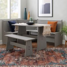 a table and bench in a room with a rug