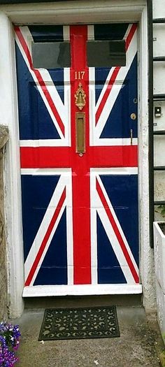 a british flag painted on the front door of a house with potted plants and flowers