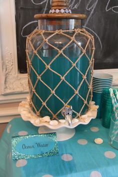 a table topped with a blue vase filled with water